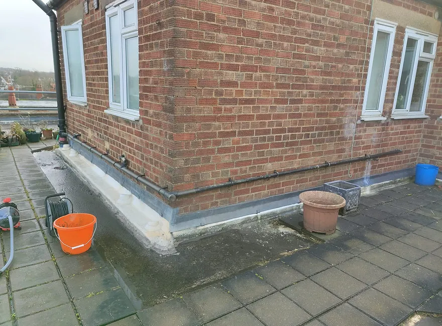a brick building with two buckets and a hose